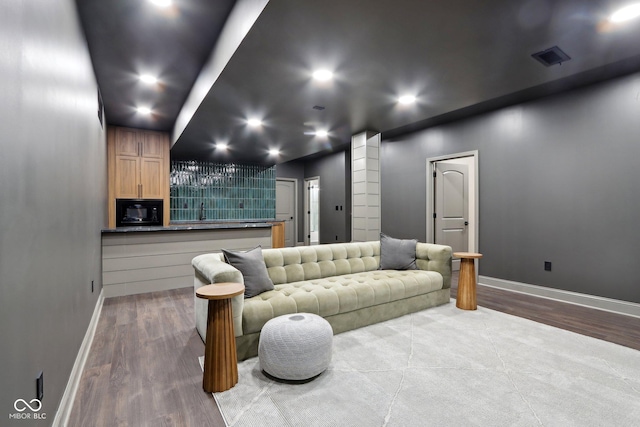 cinema room featuring indoor bar and hardwood / wood-style floors