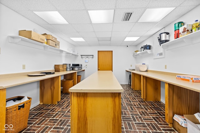 kitchen featuring a paneled ceiling and a center island