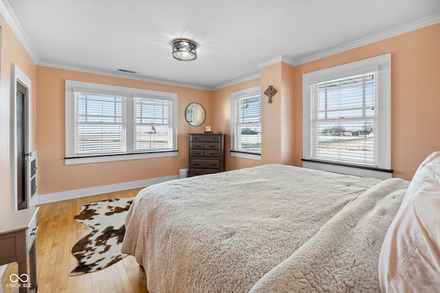 bedroom with light hardwood / wood-style floors and ornamental molding