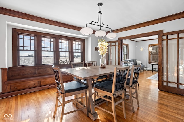 dining room with ornamental molding, baseboard heating, and light hardwood / wood-style flooring