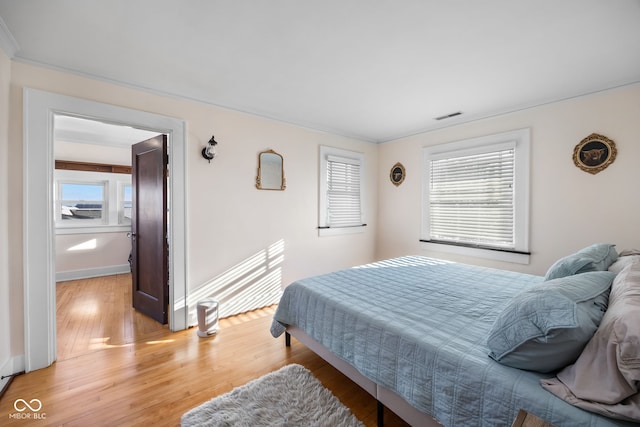 bedroom with light wood-type flooring and multiple windows