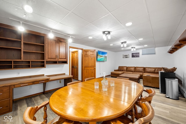 dining space with light hardwood / wood-style floors and rail lighting