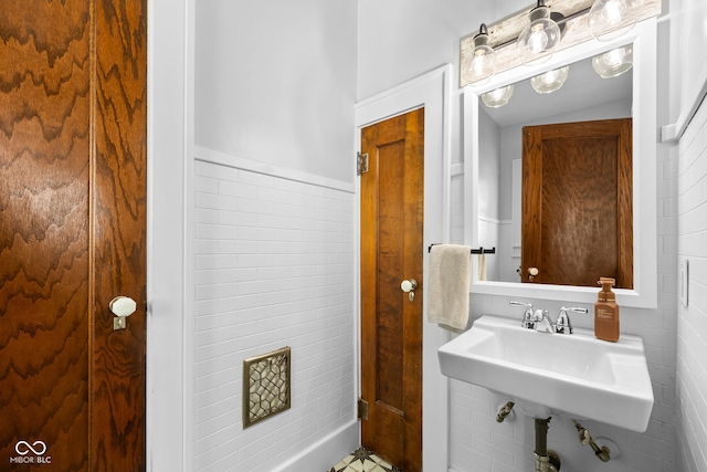 bathroom featuring tile walls and sink