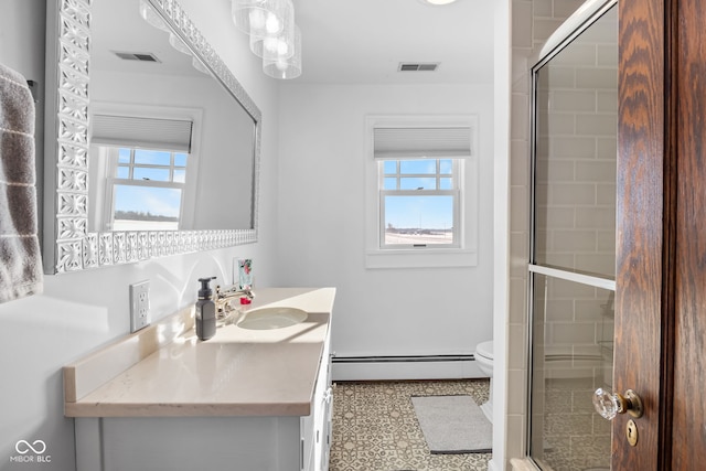 bathroom with vanity, a baseboard radiator, a shower with shower door, and a healthy amount of sunlight