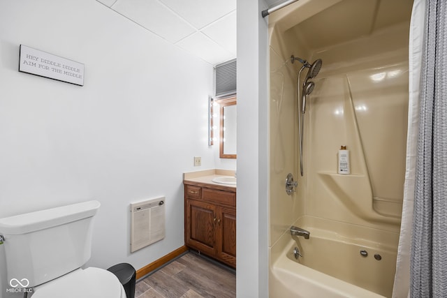 full bathroom featuring shower / bath combination with curtain, vanity, heating unit, hardwood / wood-style floors, and toilet