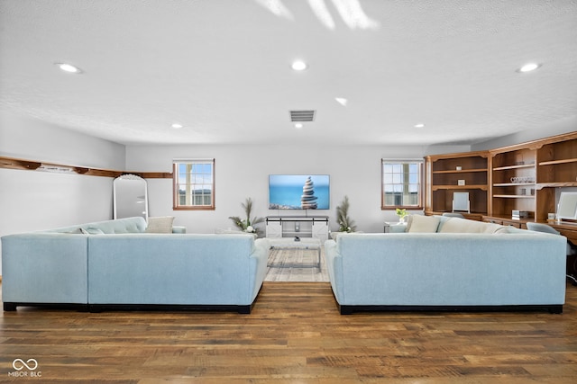 unfurnished living room featuring a textured ceiling and dark wood-type flooring