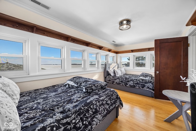 bedroom featuring hardwood / wood-style floors and crown molding