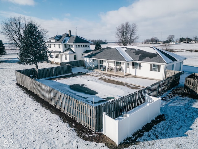 view of snow covered back of property