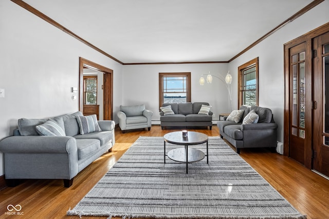 living room featuring crown molding, a healthy amount of sunlight, and light hardwood / wood-style floors