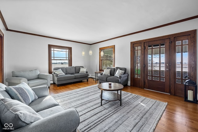 living room featuring hardwood / wood-style floors, ornamental molding, and a baseboard heating unit