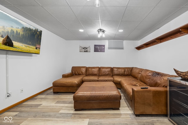 living room with wine cooler, a paneled ceiling, and light hardwood / wood-style flooring