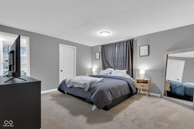 bedroom with carpet floors, baseboards, and a textured ceiling