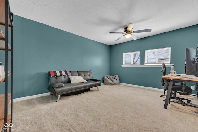 carpeted office space with ceiling fan, a textured ceiling, and baseboards