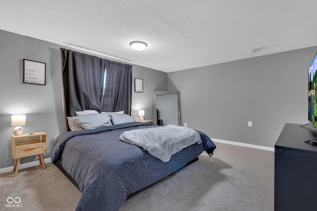 carpeted bedroom featuring a textured ceiling and baseboards