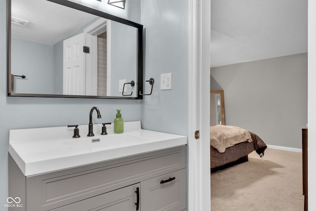 bathroom with visible vents, a textured ceiling, vanity, and baseboards