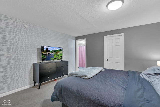 bedroom with a textured ceiling, carpet floors, and baseboards