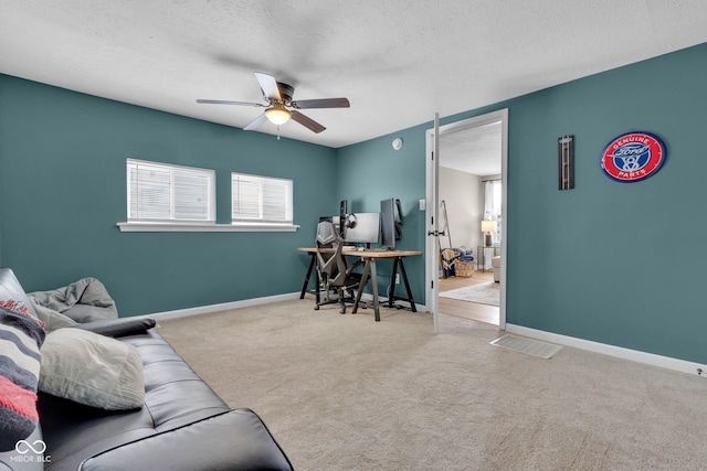 office with a textured ceiling, carpet floors, a ceiling fan, and baseboards