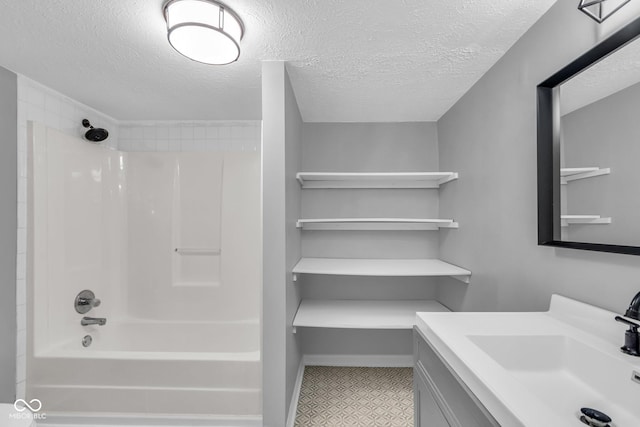 bathroom with vanity, a textured ceiling, and bathing tub / shower combination