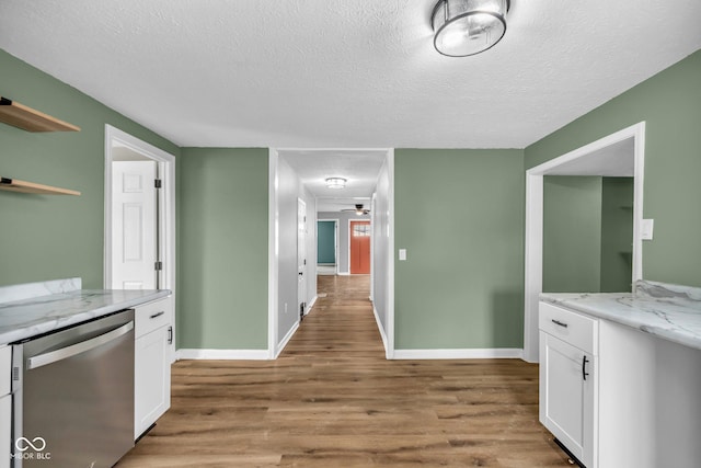 kitchen featuring open shelves, stainless steel dishwasher, white cabinetry, a textured ceiling, and wood finished floors