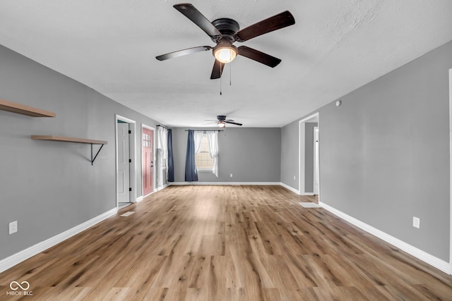 unfurnished living room with baseboards and wood finished floors