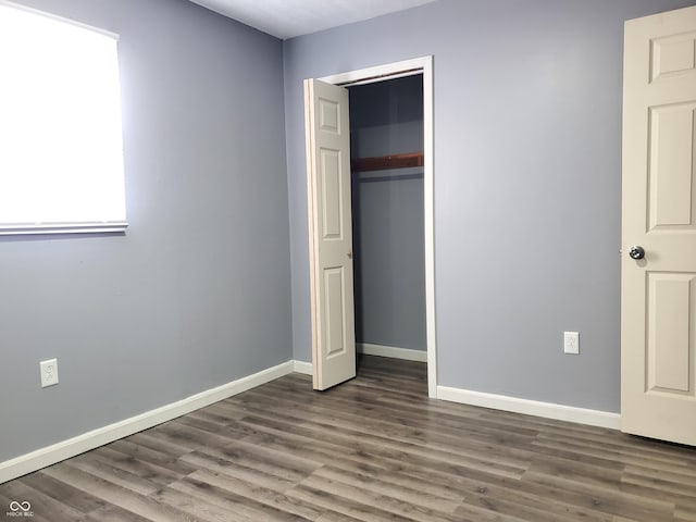 unfurnished bedroom featuring a closet and dark hardwood / wood-style floors