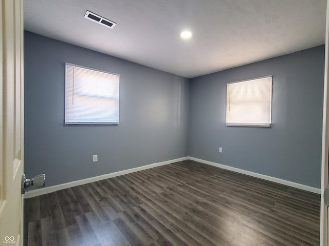 spare room with dark wood-type flooring