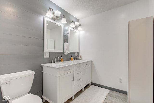 bathroom featuring vanity, toilet, and a textured ceiling