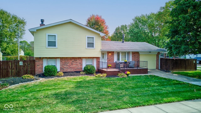 tri-level home featuring a wooden deck and a front yard