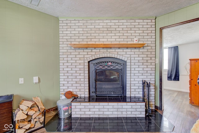 room details featuring wood-type flooring, a textured ceiling, a wood stove, and wood walls