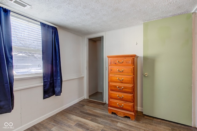 bedroom featuring wood-type flooring, a textured ceiling, and multiple windows