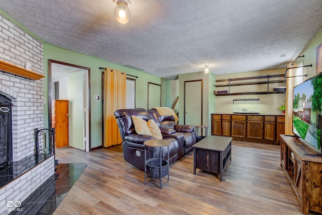 living room with a textured ceiling, a fireplace, and dark hardwood / wood-style floors