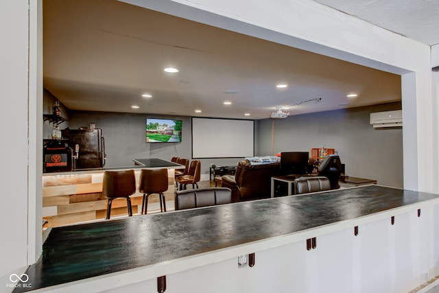 kitchen with a wall mounted air conditioner, white cabinetry, and stainless steel refrigerator