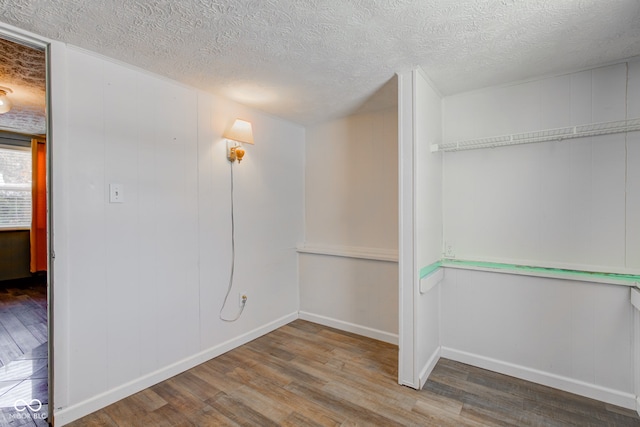 empty room featuring wood-type flooring and a textured ceiling