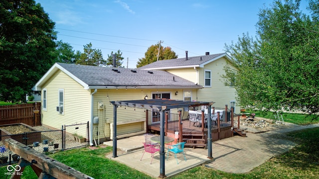 rear view of property featuring a pergola, a patio, and a wooden deck