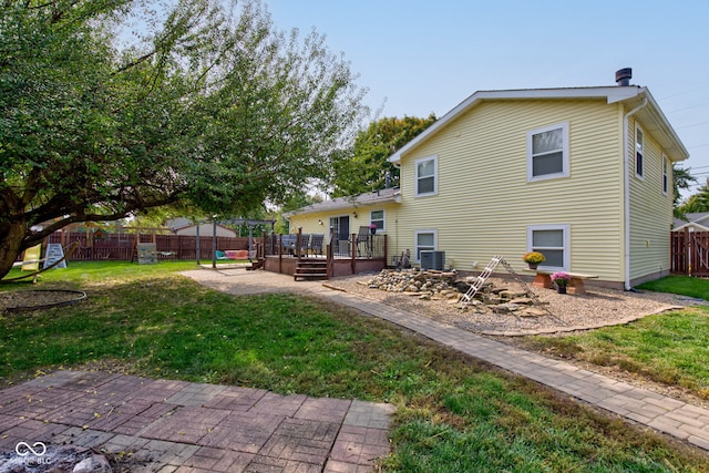 rear view of property with a yard, a patio, cooling unit, and a wooden deck