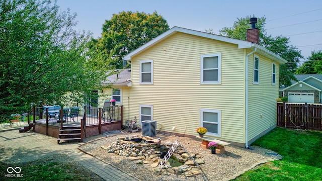 back of property with central air condition unit and a deck