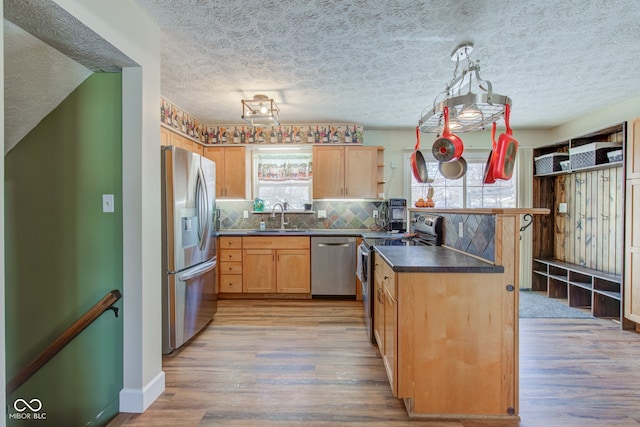 kitchen featuring backsplash, a wealth of natural light, sink, and stainless steel appliances