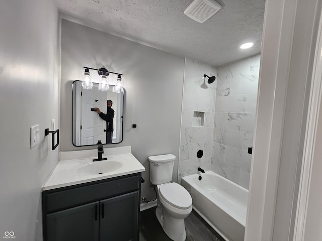 full bathroom with vanity, a textured ceiling, hardwood / wood-style floors, toilet, and tiled shower / bath