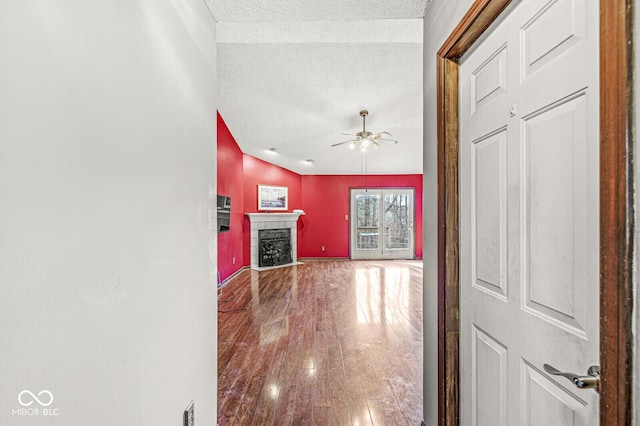 corridor featuring wood-type flooring and a textured ceiling