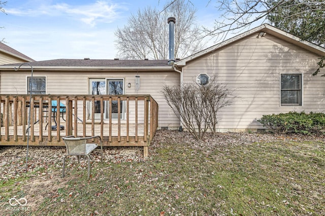 rear view of house featuring a yard and a deck