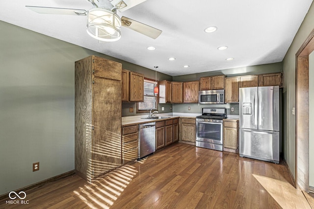 kitchen featuring pendant lighting, sink, dark wood-type flooring, and appliances with stainless steel finishes