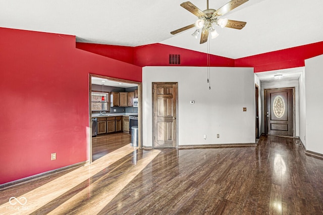 unfurnished living room featuring ceiling fan, dark hardwood / wood-style flooring, sink, and vaulted ceiling