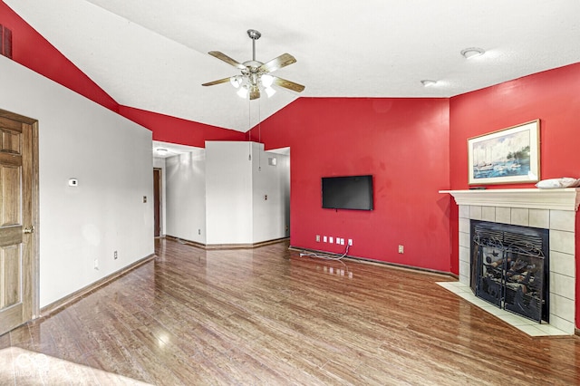 unfurnished living room with a tile fireplace, ceiling fan, wood-type flooring, and lofted ceiling