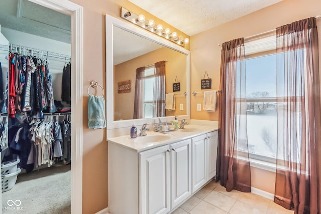 bathroom with tile patterned floors, vanity, and a textured ceiling