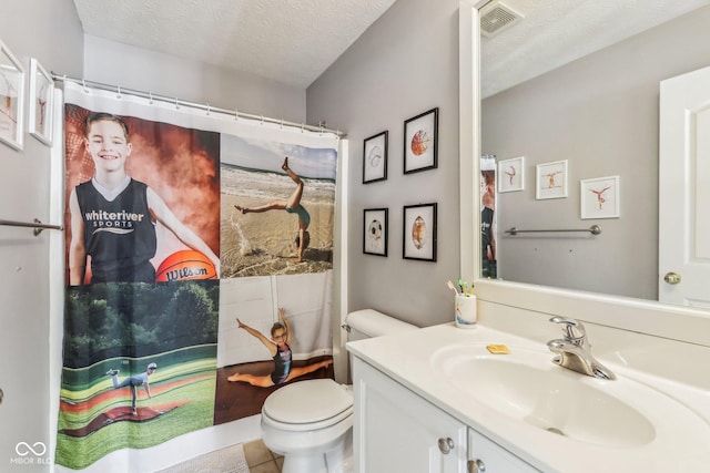 bathroom featuring vanity, a textured ceiling, and toilet