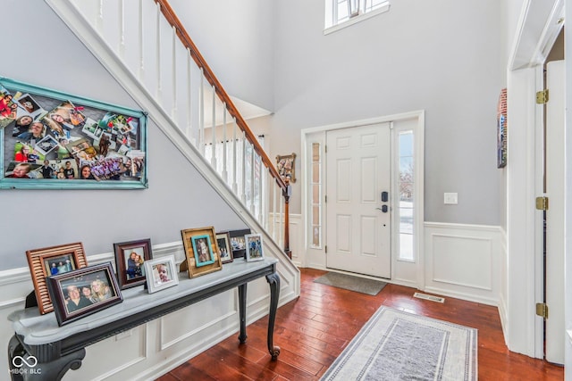 foyer entrance featuring dark hardwood / wood-style floors and a high ceiling