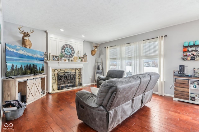 living room featuring a fireplace, dark hardwood / wood-style flooring, and a textured ceiling