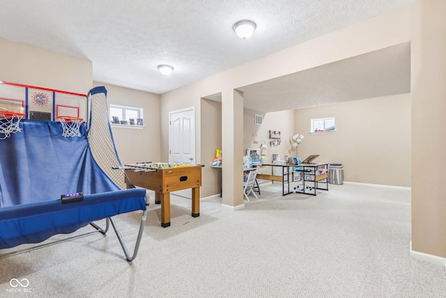 recreation room with a textured ceiling and carpet flooring