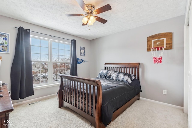 bedroom featuring ceiling fan, a textured ceiling, and carpet