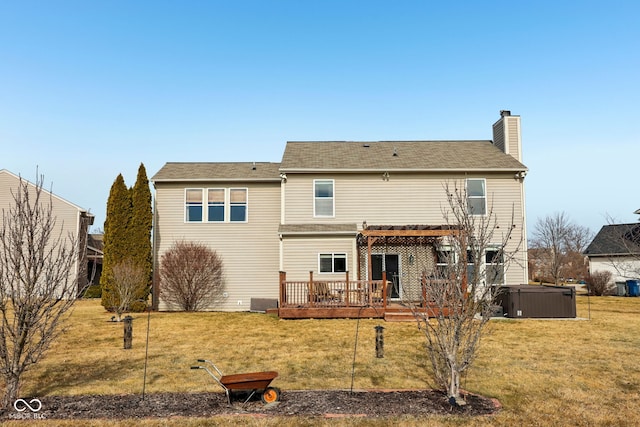 rear view of house with a hot tub, a wooden deck, a lawn, and a pergola